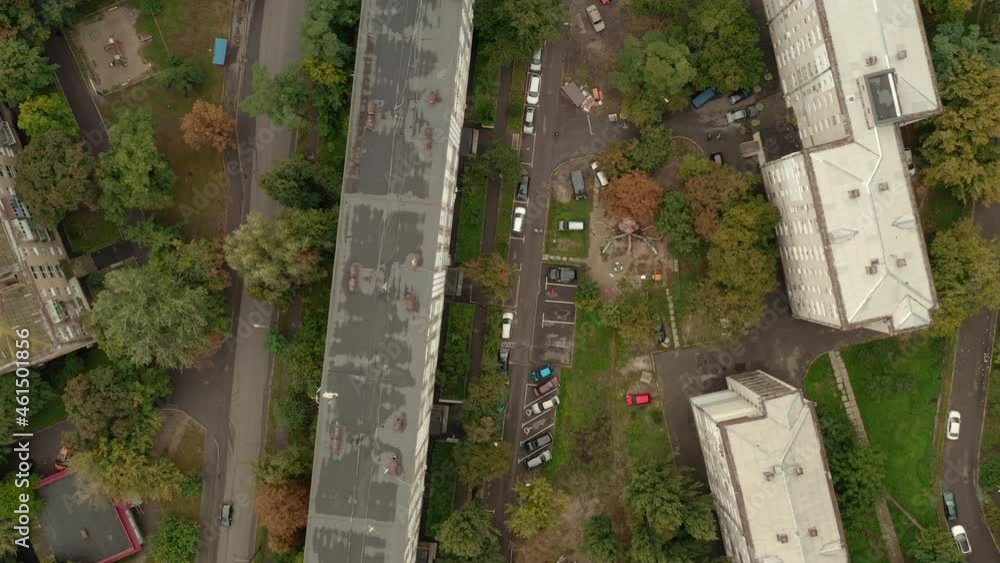 Flying over multi-storey buildings in the city: top view aerial shot. City panorama: multi-storey buildings, parking in the courtyards of apartment buildings and roads. Flying over multi-storey buildings in the city: top view aerial shot. City panorama: multi-storey buildings, parking in the courtyards of apartment buildings and roads.