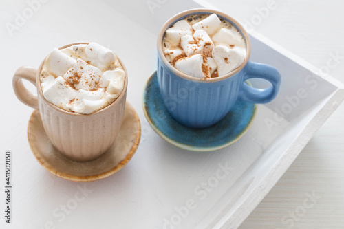 cups of cacao with marshmallows on white wooden tray