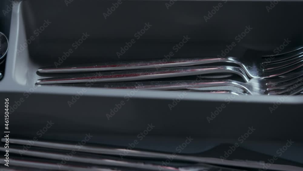 Person replacing or fetching a fork from a cutlery drawer Person replacing or fetching a fork from a cutlery drawer