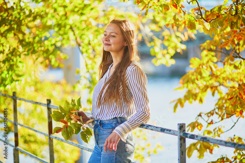 Beautiful young woman enjoying bright autumn day in Paris, France