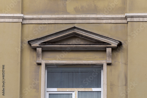 Elements of architectural decorations of buildings, sandrik over window, gypsum stucco. Plastic window in an old house.