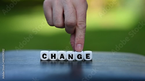 Hand is turning a dice and changes the word change to chance. photo