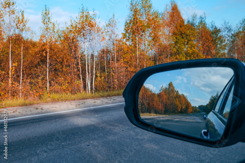 rearview mirror of a car on an asphalt road, travel concept