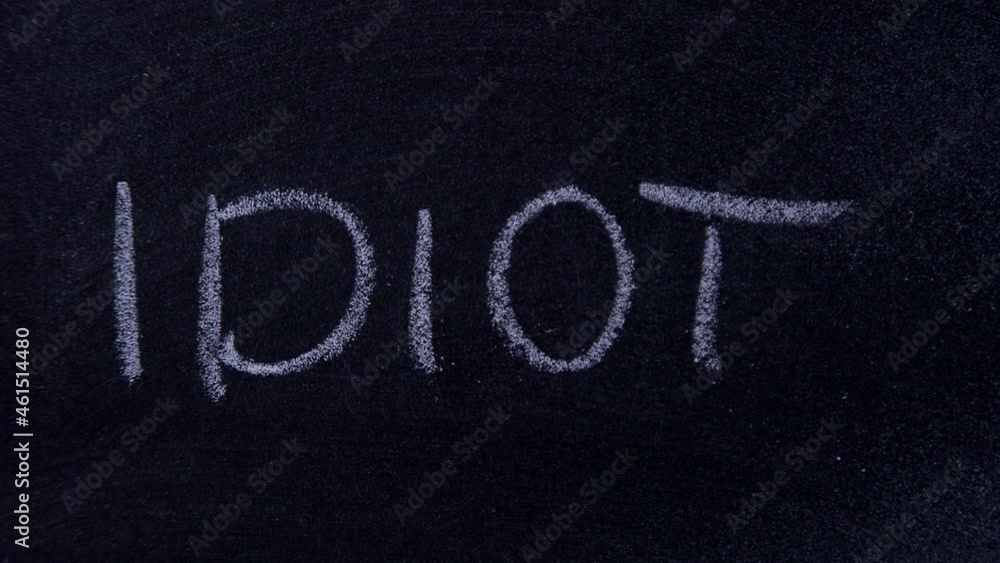 Word IDIOT written in chalk on a chalkboard Word IDIOT written in chalk on a chalkboard