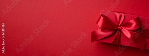 Banner with red gift box on red background for Christmas or Valentine's day.