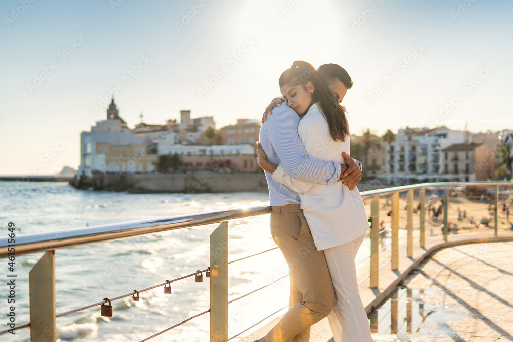 Obraz premium Tender ethnic couple embracing on embankment