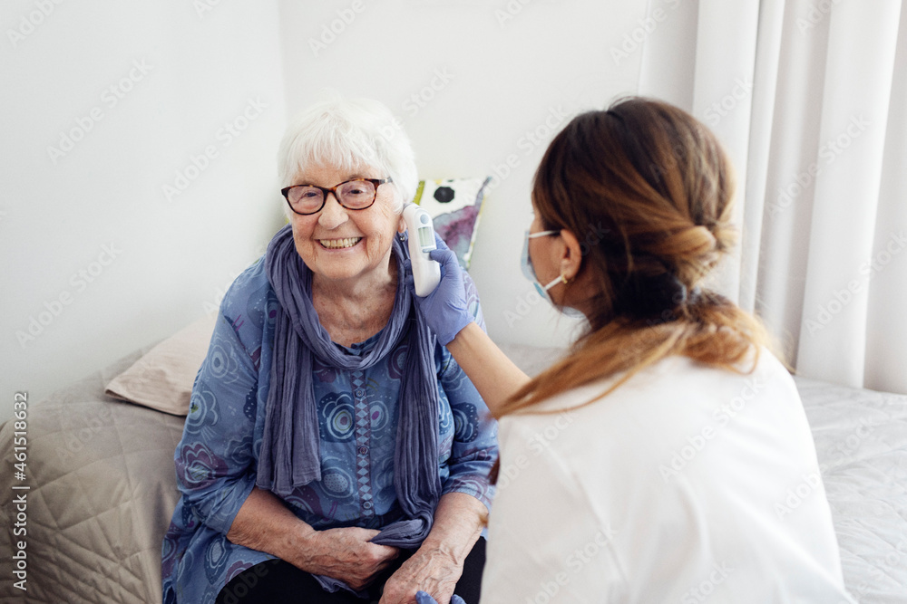 Nurse checking woman's temperature at home Nurse checking woman's temperature at home