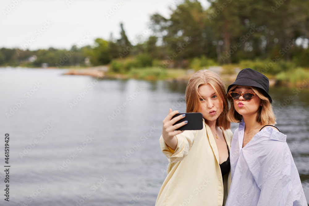 Two friends taking selfie at lakeside Two friends taking selfie at lakeside