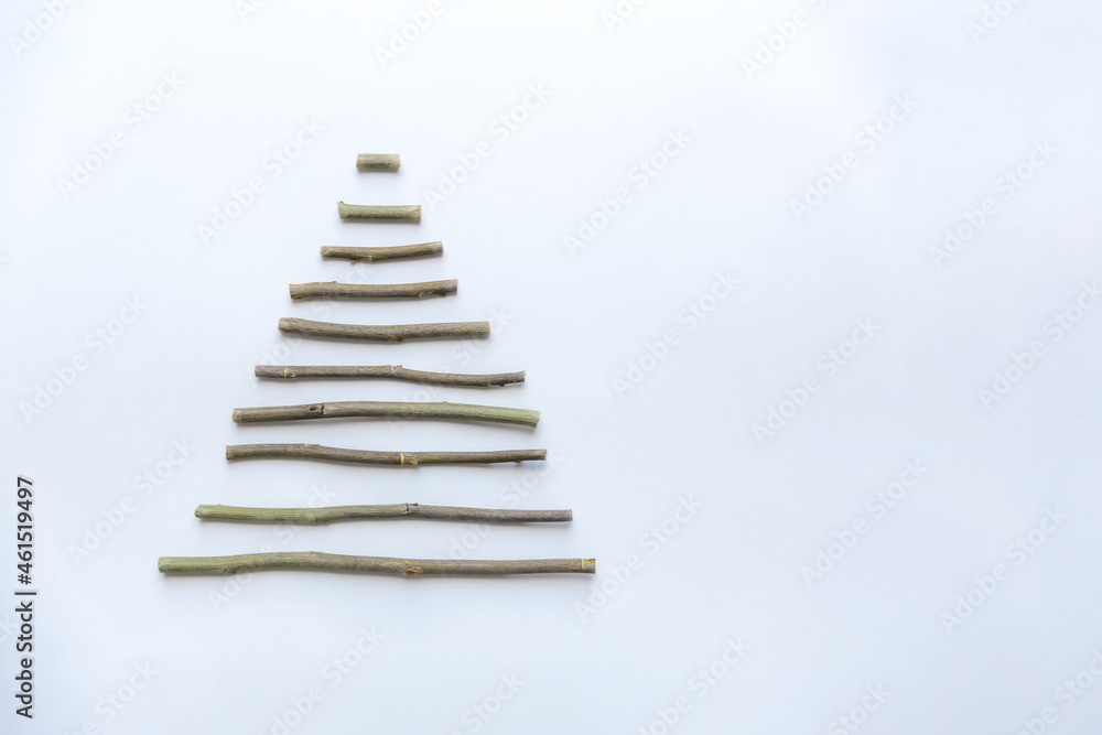A simple composition of dry sticks in the shape of a triangle, arrows on a white background. space for text. Postcard, pointer, banner A simple composition of dry sticks in the shape of a triangle, arrows on a white background. space for text. Postcard, pointer, banner