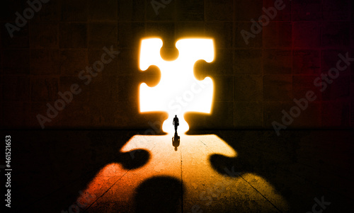 Businessman Getting out from a dark room Through a Puzzle Door. Bright Light Doorway and Business man walking in big concrete hall. Business solution and Opportunity concept 