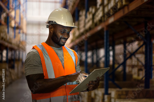 Warehouse worker using digital tablet to check stock in warehouse. 
