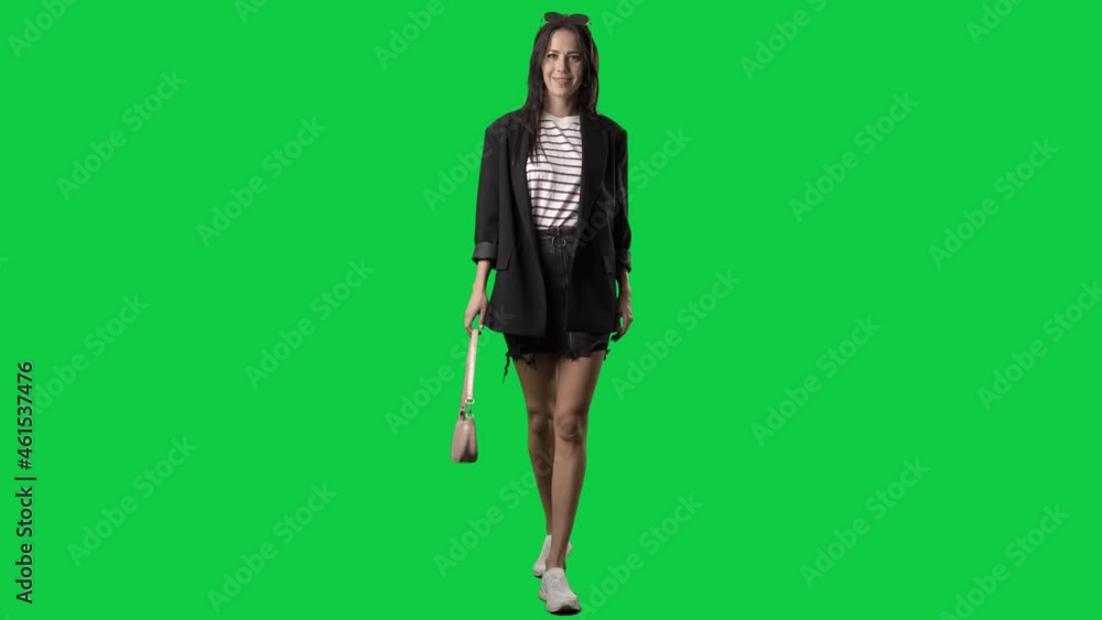 Elegant smart casual woman in blazer walking with swinging purse. Full body on green screen chroma key background Elegant smart casual woman in blazer walking with swinging purse. Full body on green screen chroma key background