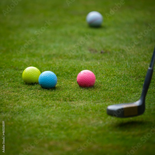 Multi-colored golf balls on green grass. Golf Club. Sports and recreation.