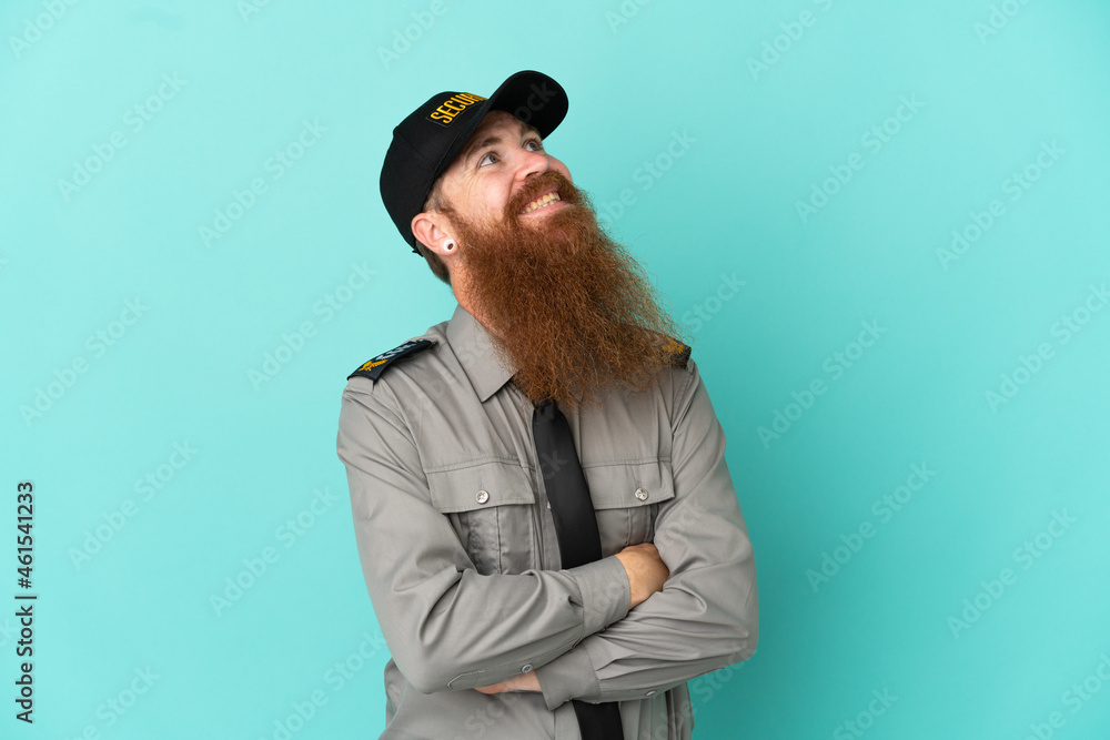 Redhead security man isolated on white background looking up while smiling Redhead security man isolated on white background looking up while smiling
