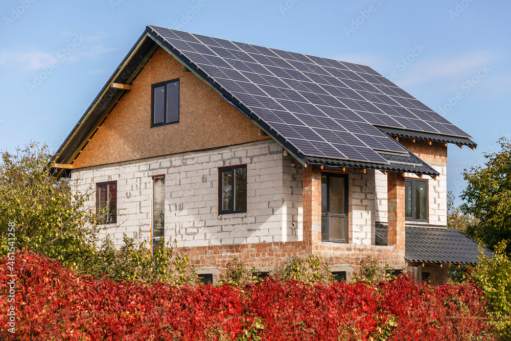 Solar panels on roof house. Solar cell. Solar array. Cell profit. Alternative energy. Blue sky background.