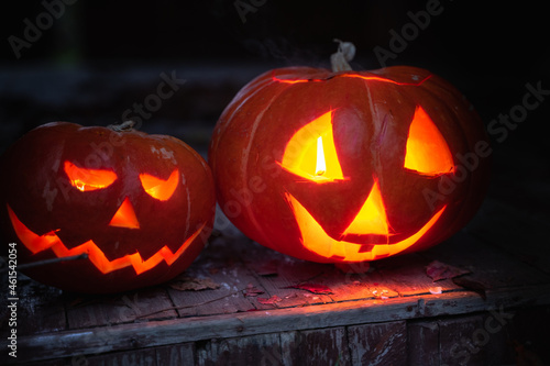 Jack-o-lantern hand made from big pumpkins with candle lights in eyes,nose,mouth. Celebratiion of halloween holiday.Cut with knife,take out pulp with seeds.Outdoors activity,backyard.Children's party