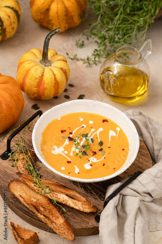Vegetarian autumn pumpkin cream soup with spices, thyme and pumpkin seeds.