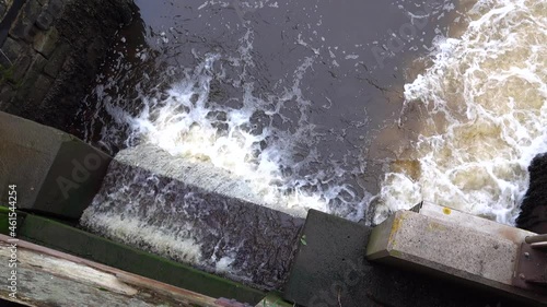 water flowing through a sluice gate in Port Penrhyn Dock, Bangor Wales UK photo