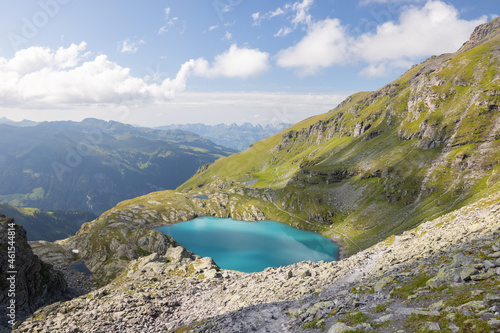 Fototapeta Naklejka Na Ścianę i Meble -  A wonderful view to the horizon at a beautiful sunset in the alps of Switzerland by an alpine lake called Schottensee. These colors by the sunset are just amazing. Epic clear blue water.
