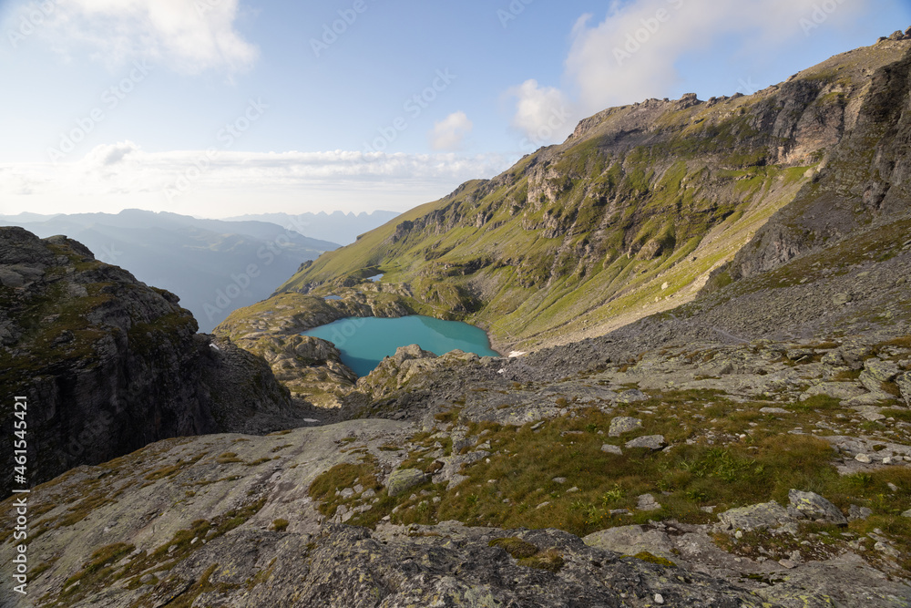 A wonderful view to the horizon at a beautiful sunset in the alps of Switzerland by an alpine lake called Schottensee. These colors by the sunset are just amazing. Epic clear blue water. A wonderful view to the horizon at a beautiful sunset in the alps of Switzerland by an alpine lake called Schottensee. These colors by the sunset are just amazing. Epic clear blue water.