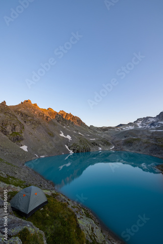 Wonderful scenery at an alpine lake called Wildsee in the canton of Saint Gallen. Epic sunset in the alps of Switzerland. Beautiful view with the tent in front and a perfect camping day.