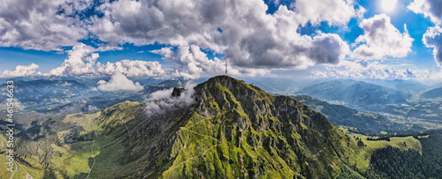 Panorama view of the Kitzbühler Horn half-covered with clouds through which the sun breaks