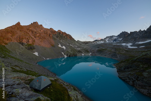 A wonderful view to the horizon at a beautiful sunset in the alps of Switzerland by an alpine lake called Schottensee. These colors by the sunset are just amazing. Epic clear blue water.