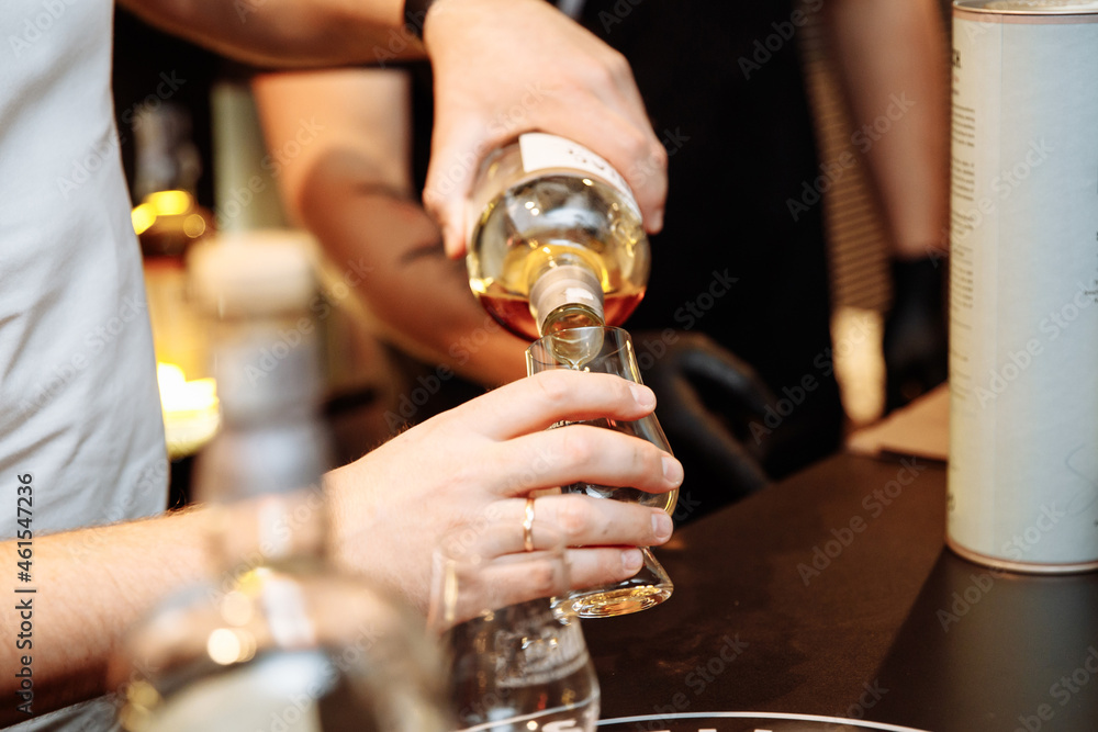 Man serving alcoholic drink into a glass