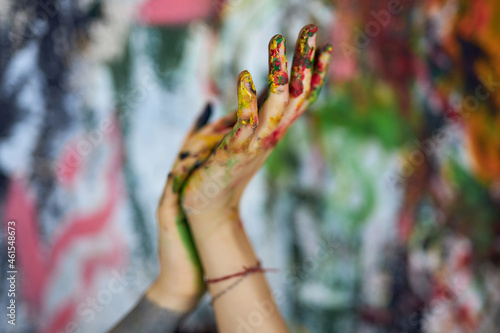 Canvastavla Close up shot of hands in colorful paints of female painter with abstract painti