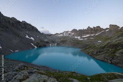 Fototapeta Naklejka Na Ścianę i Meble -  Wonderful morning view over an beautiful alpine lake called Wildsee in Switzerland. Amazing clear blue lake and the sun shine to the peaks of the glacier.