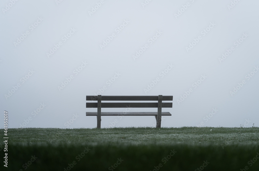 Empty bench at a lake on a morning with dense fog. Empty bench at a lake on a morning with dense fog.