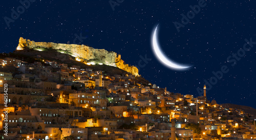 Mardin old town at twilight blue hour Crescent moon in the background - Mardin  Turkey 