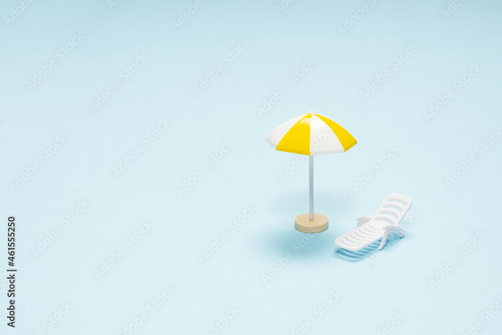 Travel concept. Sun lounger, yellow umbrella on a blue background.