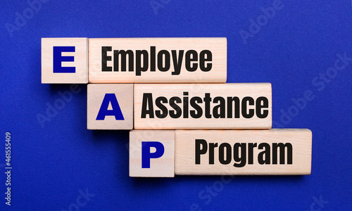 On a bright blue background, light wooden blocks and cubes with the text EAP Employee Assistance Program