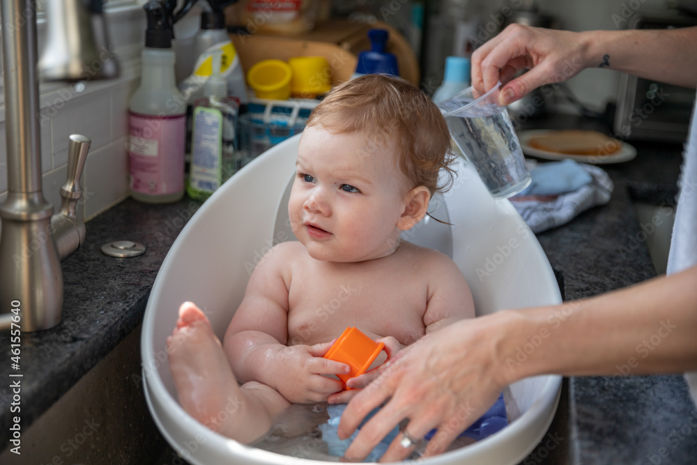 Baby boy taking bath in sink bathtub. Stock Photo Adobe Stock