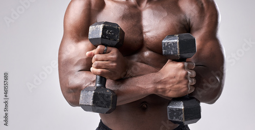 technique of doing an exercise with dumbbell of cropped muscular strong african american sportsman isolated on white studio background, portrait. sport and motivation concept. bodybuilding, fitness