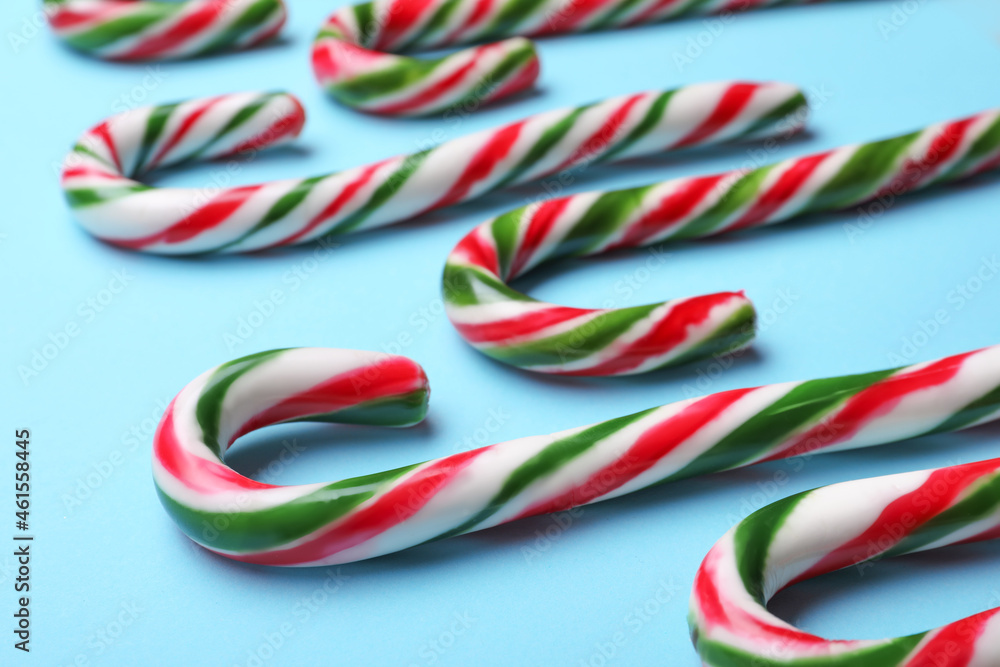 Fototapeta premium Many sweet Christmas candy canes on light blue background, closeup