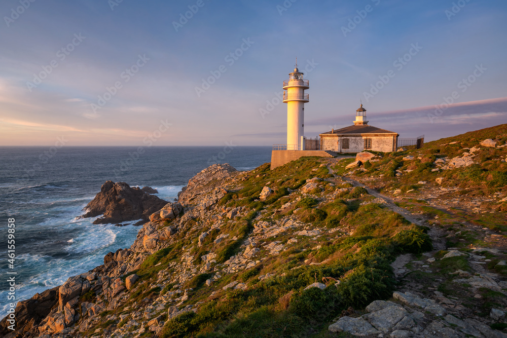Sea landscape view of Cape Tourinan Lighthouse at sunset with pink clouds, in Spain