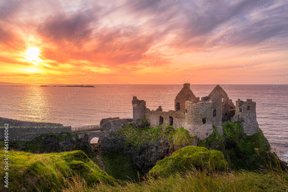 Sunset at ruins of Dunluce Castle located on the edge of cliff, Bushmills, Northern Ireland. Filming location of popular TV show Game of Thrones