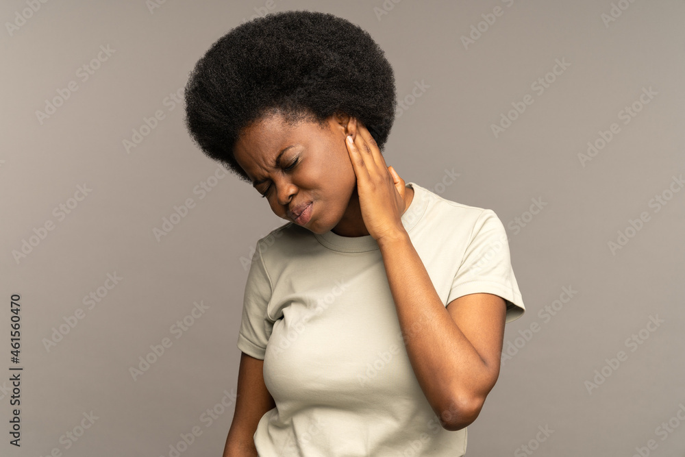 Young african woman suffer from pain in neck massaging hurting muscles to relief pressure after long work at computer and office worker syndrome. Tired upset black female touching painful shoulders Young african woman suffer from pain in neck massaging hurting muscles to relief pressure after long work at computer and office worker syndrome. Tired upset black female touching painful shoulders