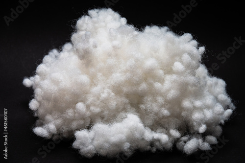 Synthetic fiber, siliconized holofiber, polyester fiber, white synthetic winterizer on a black background. It is used as a filler for blankets, pillows, clothes and upholstered furniture. Close-up. photo