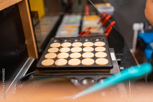 The process of making fresh delicious poffertjes. Making fresh poffertjes.Traditional Dutch batter treat. Selective focus