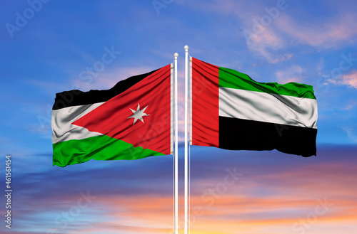 United Arab Emirates and Jordan flag waving in the wind against white cloudy blue sky together. Diplomacy concept, international relations photo