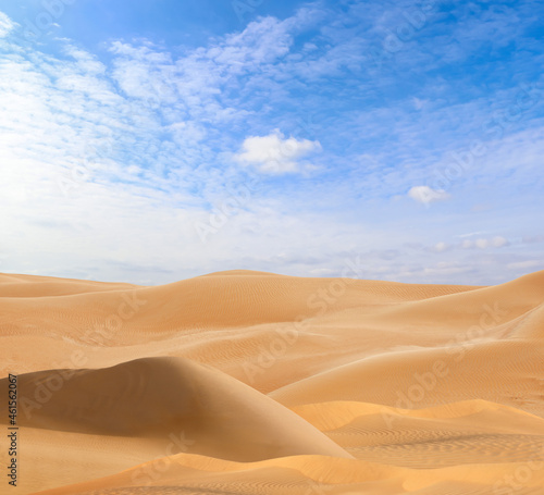 Picturesque view of sandy desert and blue sky on hot sunny day