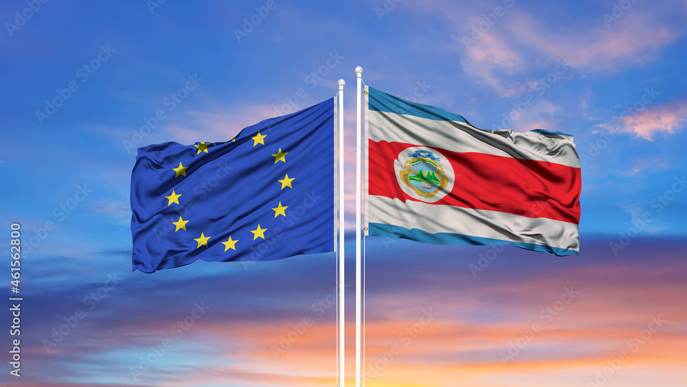 European Union and Costa Rica two flags on flagpoles and blue cloudy sky