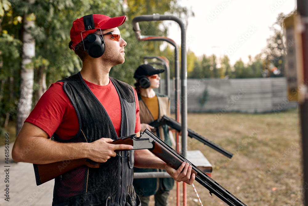 © Roman - Side View On male Looking at side after shooting. Firearms for sports shooting, hobby.strong confident man in goggles, headset hold weapon. purpose and success. man ready to fire. hunter hobby. © Roman - Side View On male Looking at side after shooting. Firearms for sports shooting, hobby.strong confident man in goggles, headset hold weapon. purpose and success. man ready to fire. hunter hobby.