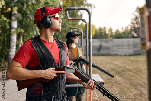 Side View On male Looking at side after shooting. Firearms for sports shooting, hobby.strong confident man in goggles, headset hold weapon. purpose and success. man ready to fire. hunter hobby.