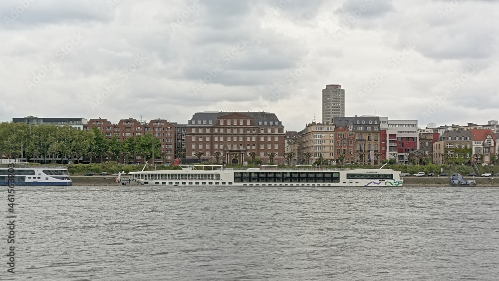 Naklejka premium Church and apartment buildings and cruise boats along river Rhine in Cologne