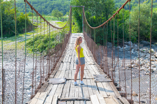 a woman stands on a suspension bridge in Georgia photo