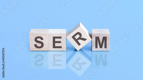 SERM word is made of wooden cubes lying on the blue table, concept